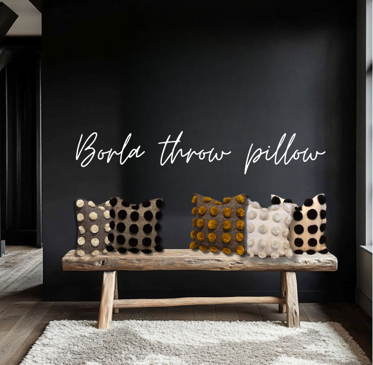 Decorative pillows on a wooden bench against a dark wall with 'Borla throw pillow' text.